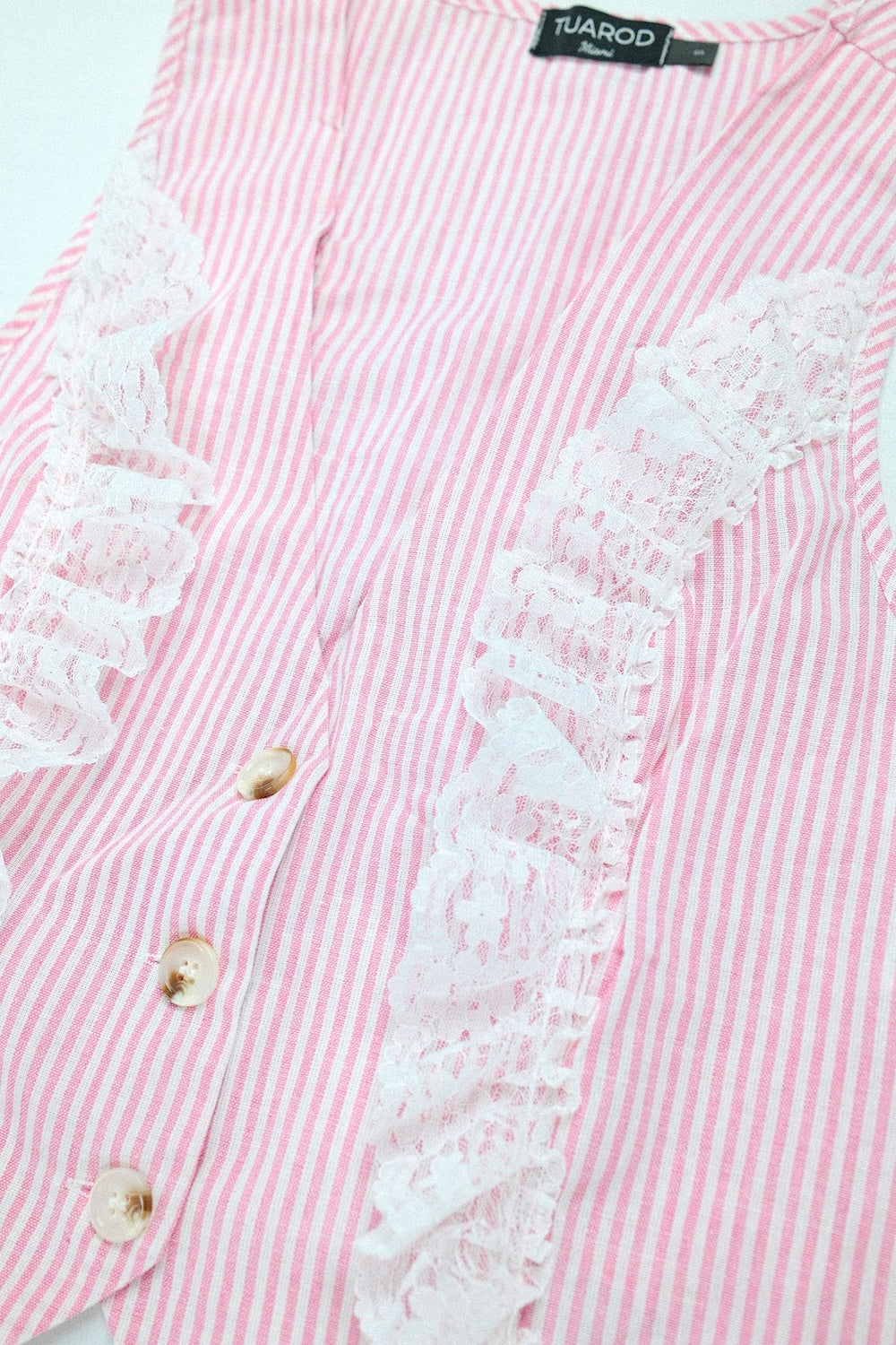 Conjunto de pantalón con bolsillos y blusa sin mangas con botones en la parte delantera a rayas rosas con detalle de encaje