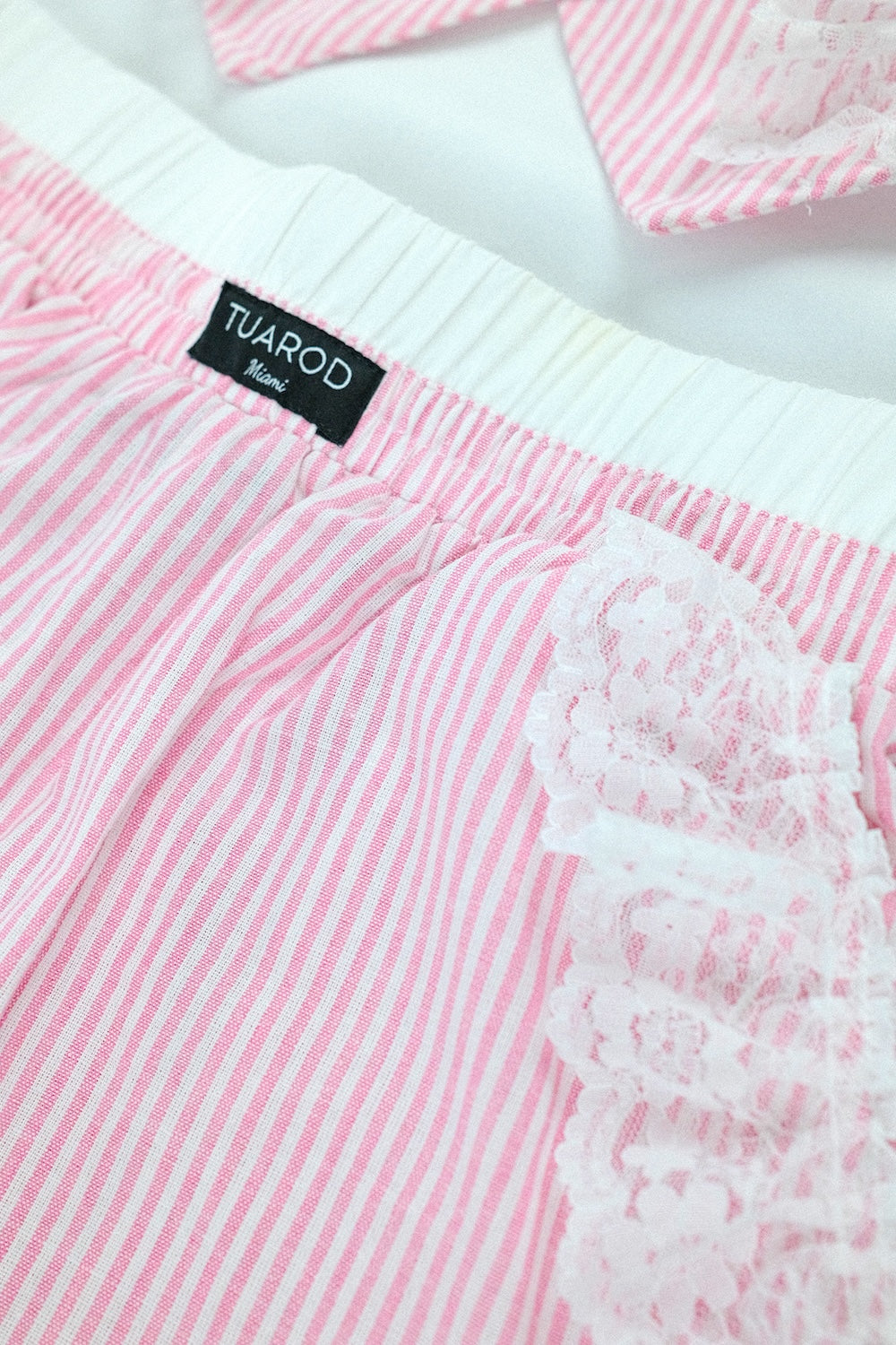 Conjunto de pantalón con bolsillos y blusa sin mangas con botones en la parte delantera a rayas rosas con detalle de encaje