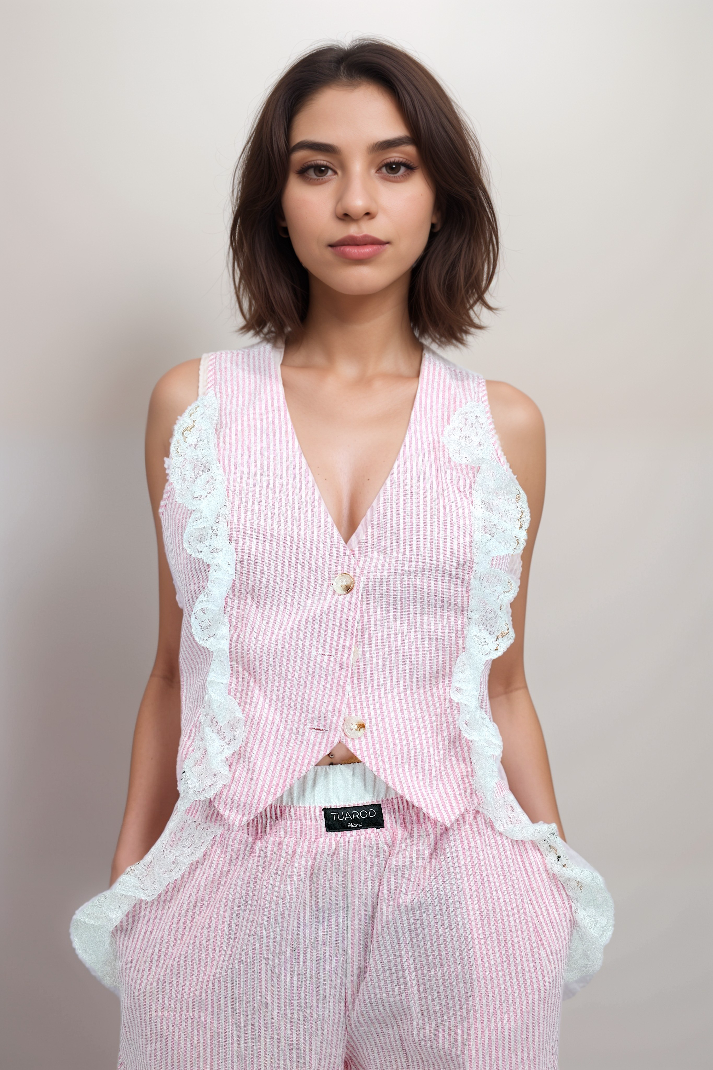 Conjunto de pantalón con bolsillos y blusa sin mangas con botones en la parte delantera a rayas rosas con detalle de encaje