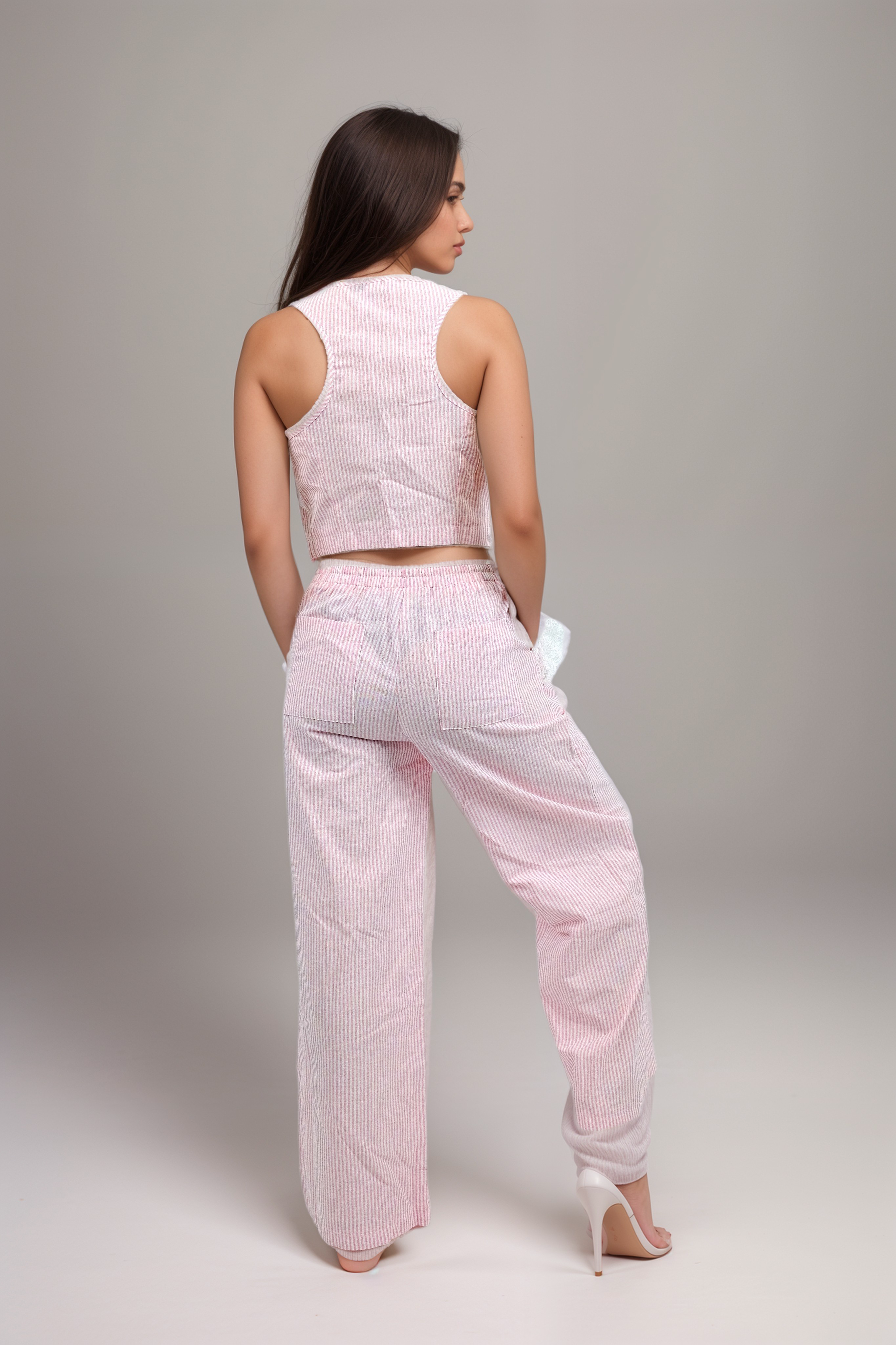 Conjunto de pantalón con bolsillos y blusa sin mangas con botones en la parte delantera a rayas rosas con detalle de encaje