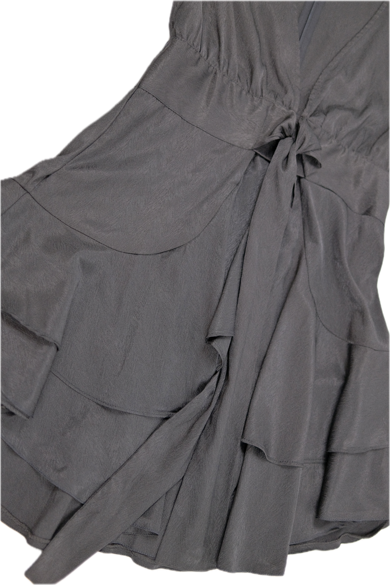 Vestido negro corto de capas, mangas largas, cinturón anudado y cremallera en la espalda